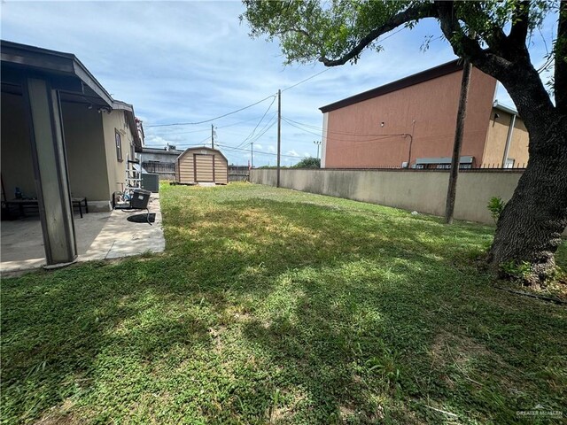 view of yard with a storage shed and a patio