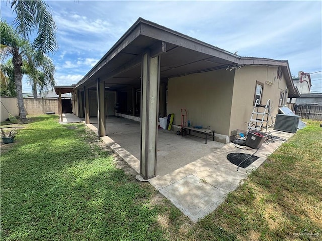 back of property with a yard, a patio, and central air condition unit