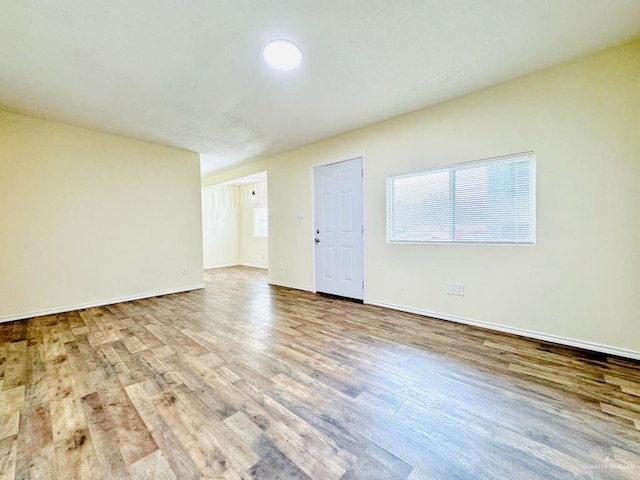 unfurnished room with a healthy amount of sunlight and wood-type flooring