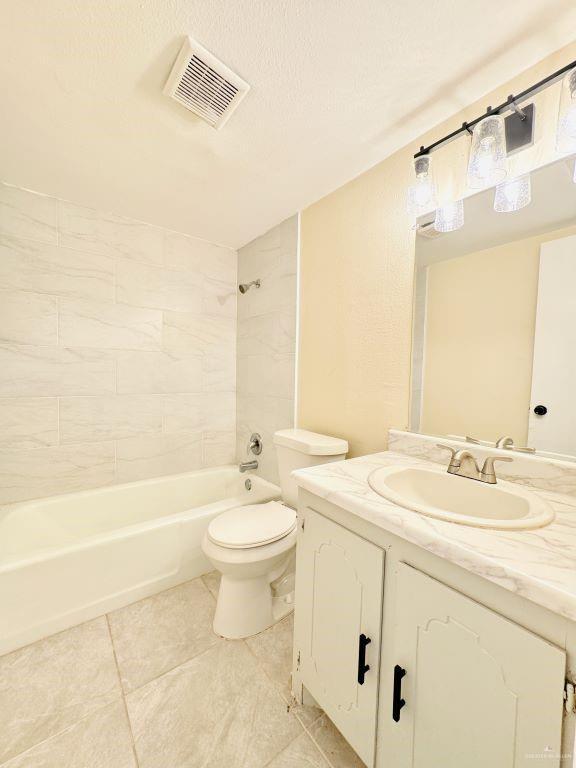 full bathroom with vanity, toilet, and tiled shower / bath