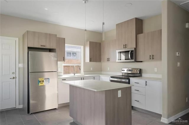 kitchen with a center island, sink, hanging light fixtures, light tile patterned floors, and stainless steel appliances