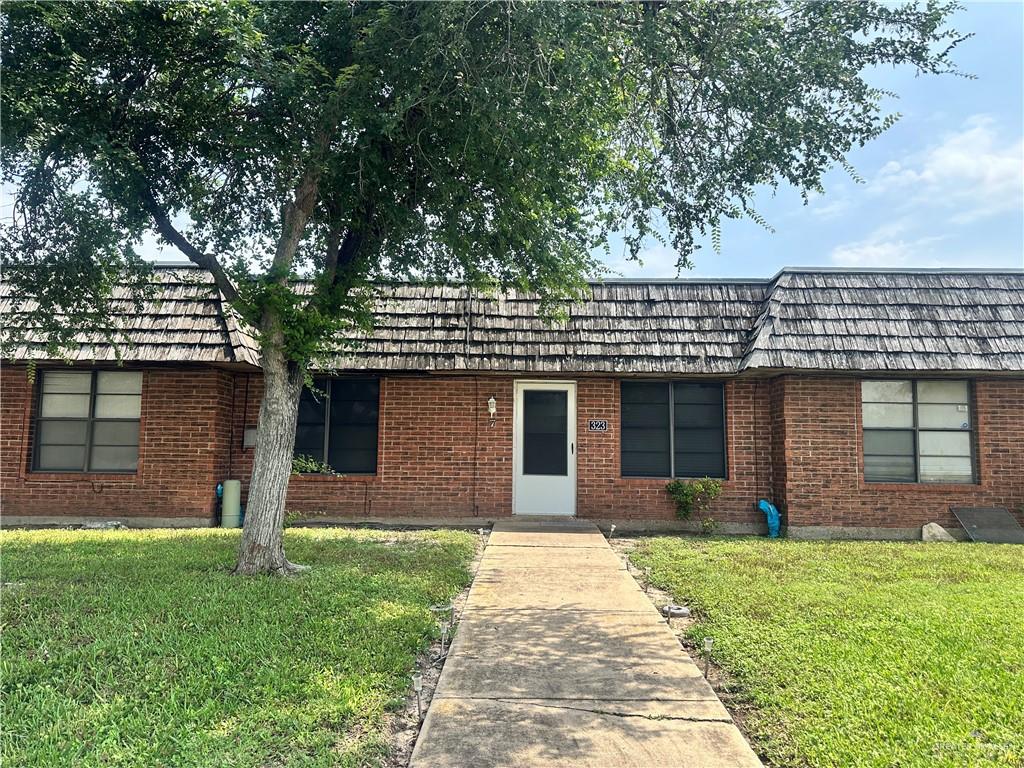 323 Forest Hills Dr Unit 7, Weslaco, TX 78596 - ranch-style home featuring brick siding, a front lawn, and mansard roof