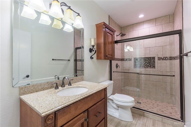 bathroom with vanity, toilet, wood-type flooring, and a shower with shower door