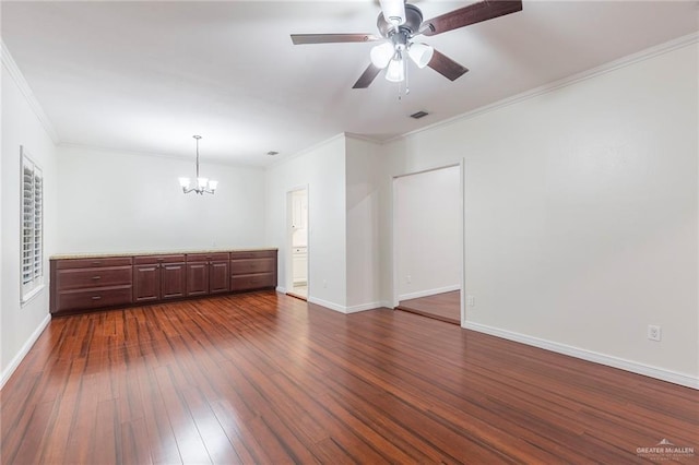 empty room with crown molding, dark wood-type flooring, and ceiling fan with notable chandelier