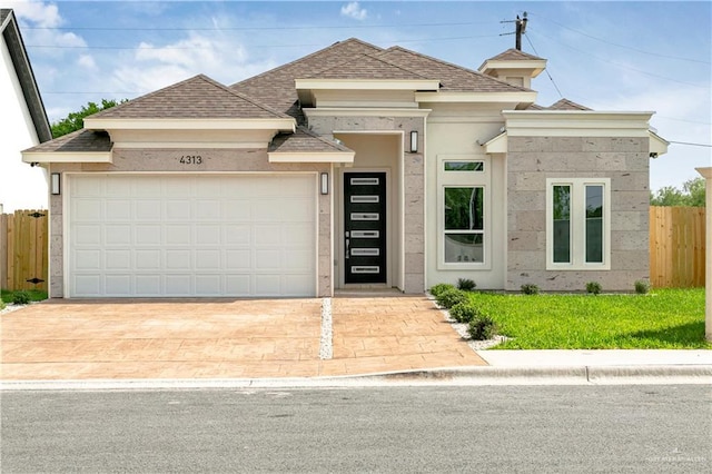 4313 Xenops Ave, Mcallen, TX 78504 - view of front of home featuring roof with shingles, an attached garage, driveway, and stucco siding