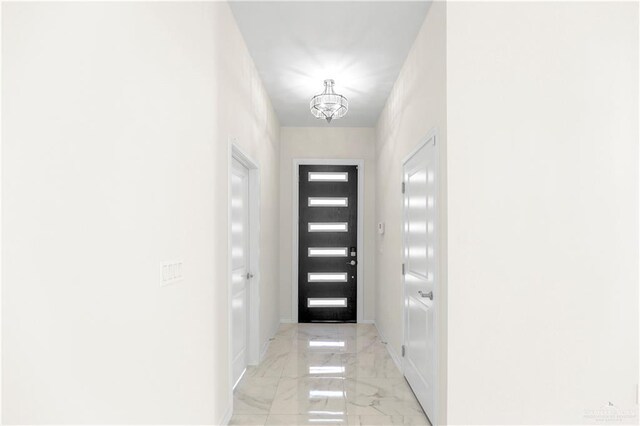 4313 Xenops Ave, Mcallen, TX 78504 - doorway to outside featuring a chandelier, light marble finish flooring, and baseboards