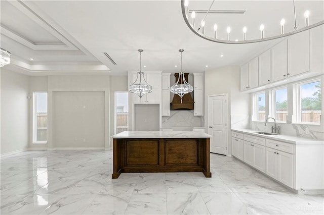 4313 Xenops Ave, Mcallen, TX 78504 - kitchen with a sink, decorative backsplash, a kitchen island, white cabinets, and a chandelier