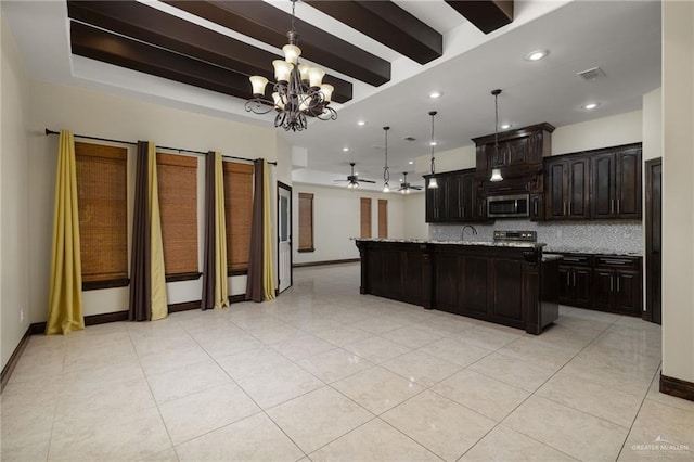 kitchen with light tile patterned floors, visible vents, a kitchen island with sink, stainless steel microwave, and backsplash