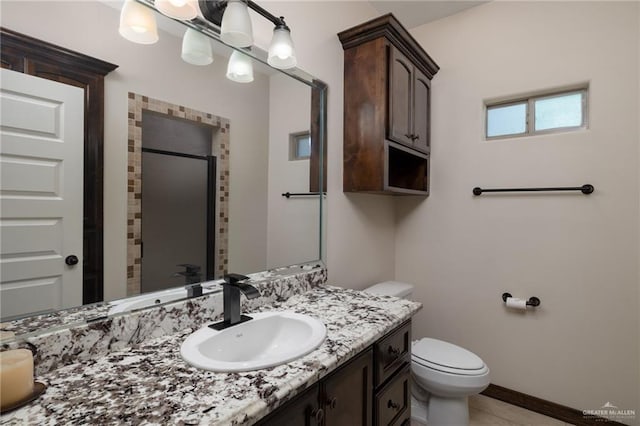 full bathroom featuring vanity, baseboards, a stall shower, tile patterned flooring, and toilet