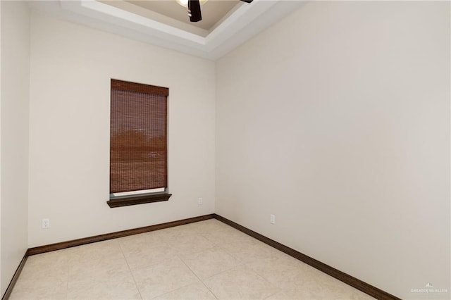 unfurnished room with a raised ceiling, baseboards, and ceiling fan