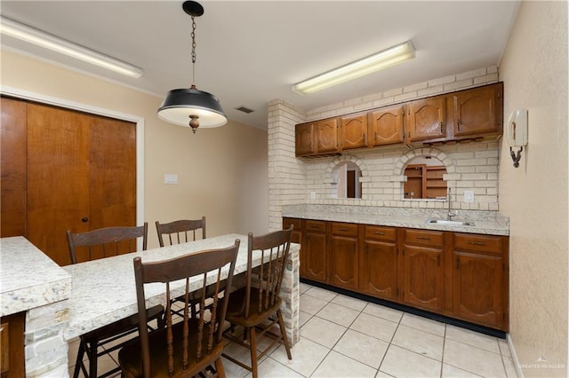 509 Lincoln Ln, La Feria, TX 78559 - kitchen with tasteful backsplash, a sink, light countertops, light tile patterned floors, and decorative light fixtures