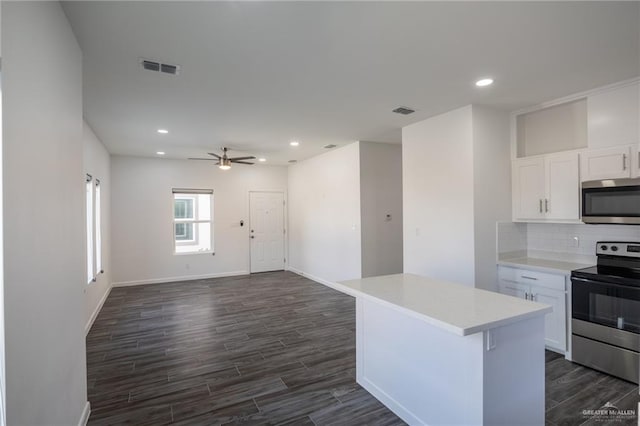 kitchen featuring white cabinetry, a kitchen island, stainless steel appliances, and ceiling fan