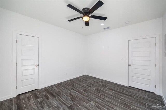 unfurnished room with dark hardwood / wood-style flooring and ceiling fan