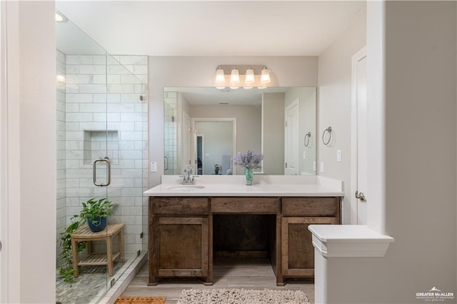 full bath featuring vanity, wood finished floors, and a shower stall