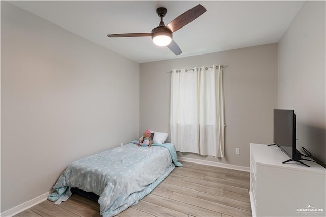 bedroom with baseboards, a ceiling fan, and light wood finished floors