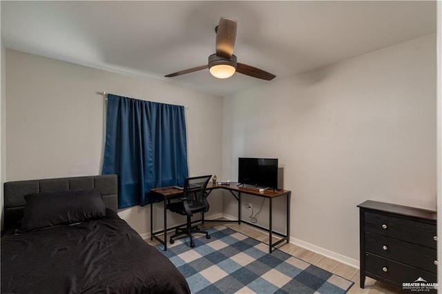 bedroom with a ceiling fan, wood finished floors, and baseboards