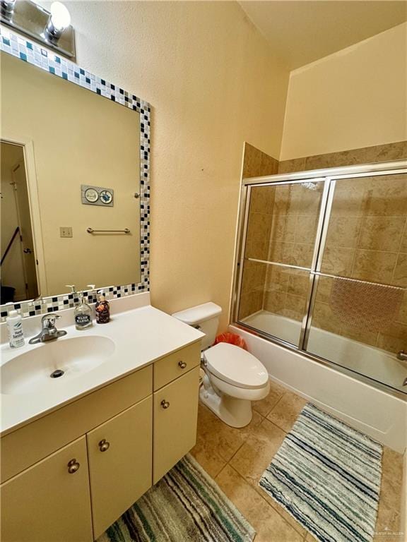 full bathroom with tile patterned flooring, vanity, enclosed tub / shower combo, and toilet