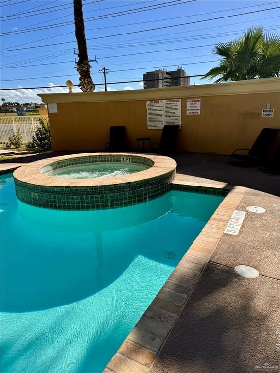 view of swimming pool featuring a hot tub