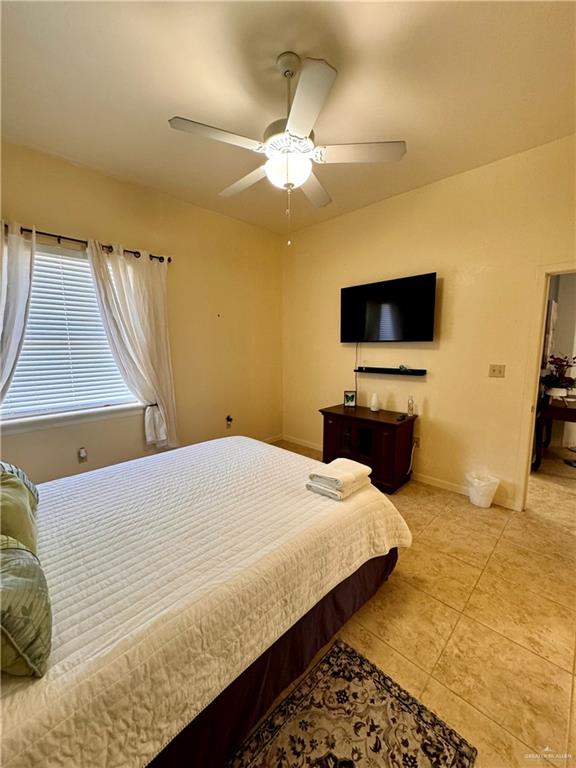 tiled bedroom featuring ceiling fan