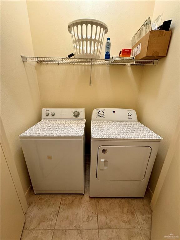 laundry area featuring washer and clothes dryer and light tile patterned flooring