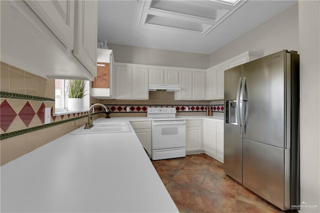 kitchen featuring stainless steel fridge, tasteful backsplash, white electric range oven, sink, and white cabinetry