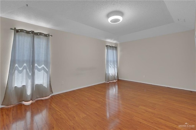 spare room with hardwood / wood-style floors and a textured ceiling