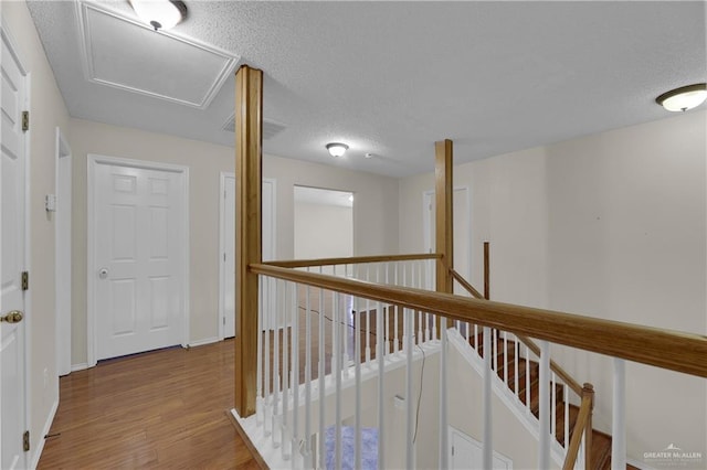 hall featuring a textured ceiling and light wood-type flooring