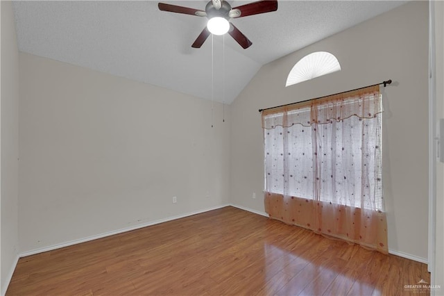 unfurnished bedroom with lofted ceiling, ceiling fan, wood-type flooring, and a textured ceiling