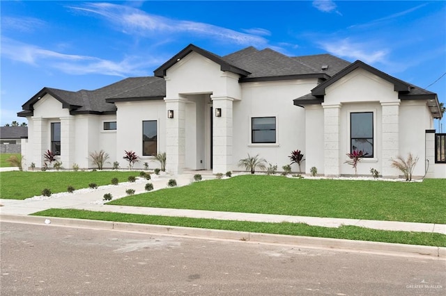 view of front of house with a shingled roof, a front lawn, and stucco siding