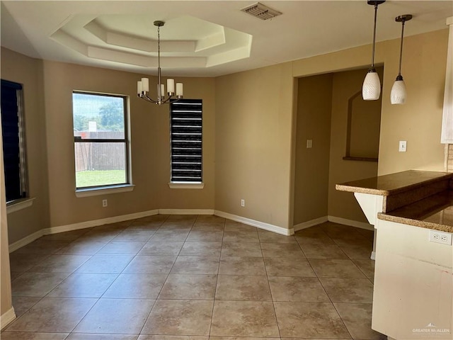 1311 Anahi St, Alamo, TX 78516 - unfurnished dining area with light tile patterned floors, a tray ceiling, a chandelier, and baseboards