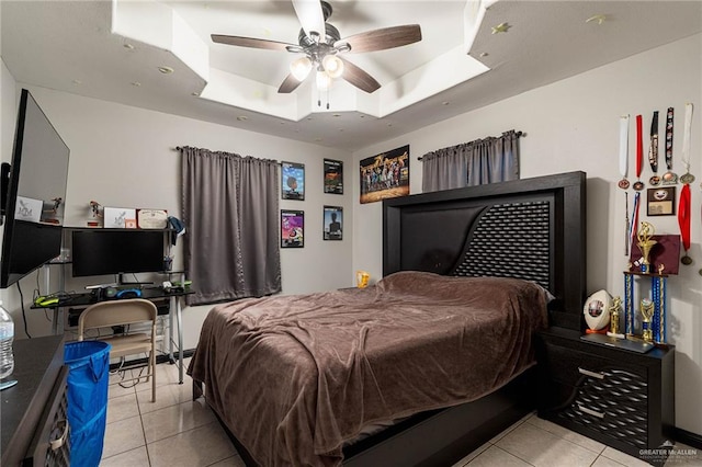 tiled bedroom featuring a raised ceiling and ceiling fan