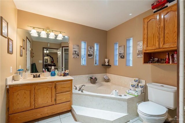 bathroom featuring toilet, vanity, a relaxing tiled tub, and tile patterned floors