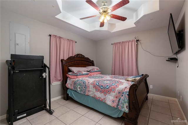 tiled bedroom with a tray ceiling and ceiling fan