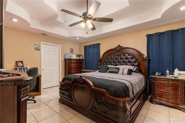 tiled bedroom with a tray ceiling and ceiling fan