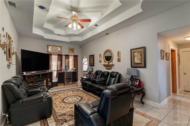 tiled living room featuring a tray ceiling and ceiling fan