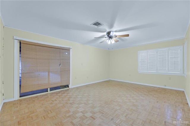 empty room featuring ceiling fan, crown molding, and light parquet flooring