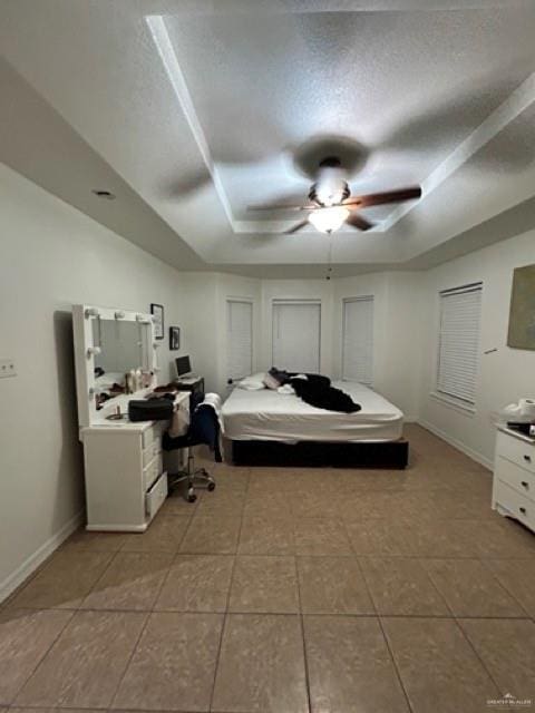 bedroom with light tile patterned floors, a raised ceiling, and ceiling fan