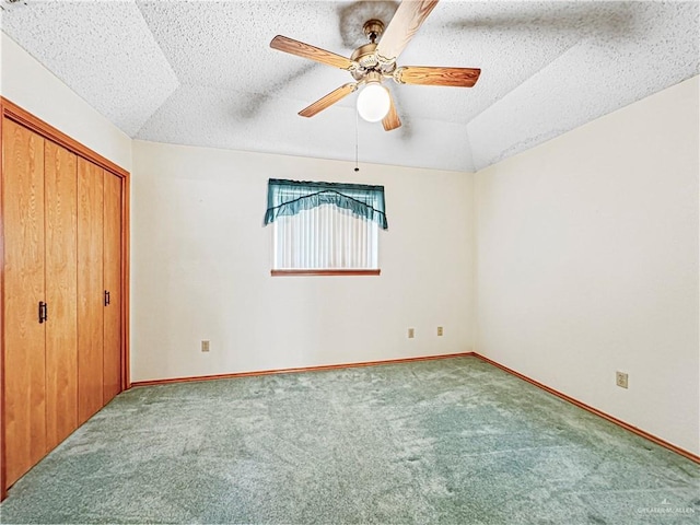 unfurnished bedroom featuring a textured ceiling, carpet floors, a closet, and ceiling fan