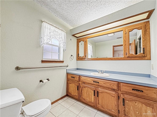 bathroom with tile patterned flooring, vanity, toilet, and a textured ceiling