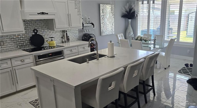 218 Stella Dr, San Juan, TX 78589 - kitchen featuring light marble finish floors, a sink, oven, ventilation hood, and black electric cooktop