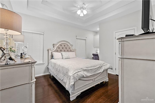3313 Cornell Ave, Mcallen, TX 78504 - bedroom featuring dark wood finished floors, a tray ceiling, baseboards, and ceiling fan