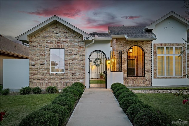 3313 Cornell Ave, Mcallen, TX 78504 - doorway to property with a lawn, roof with shingles, and stucco siding