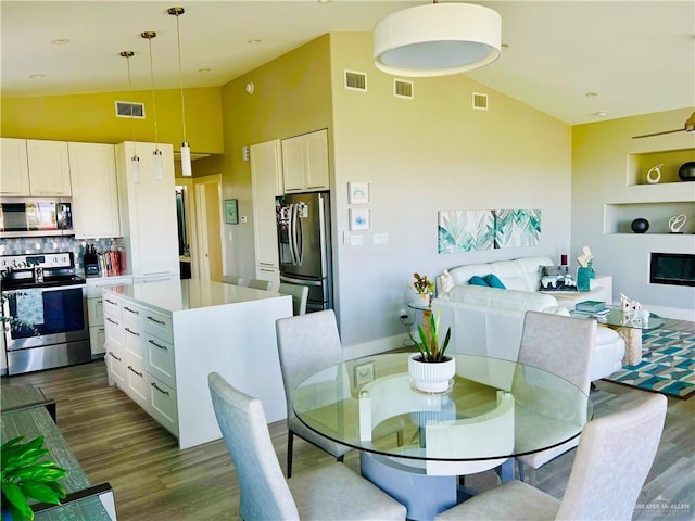 572 Sand Dollar Dr, Port Isabel, TX 78578 - dining room with dark wood-style flooring, high vaulted ceiling, and built in shelves