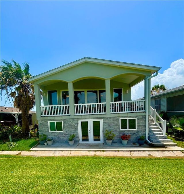572 Sand Dollar Dr, Port Isabel, TX 78578 - back of property featuring a yard, french doors, a balcony, and stairway