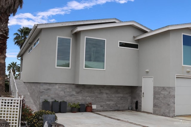 572 Sand Dollar Dr, Port Isabel, TX 78578 - view of side of property featuring stucco siding, a patio area, and a garage