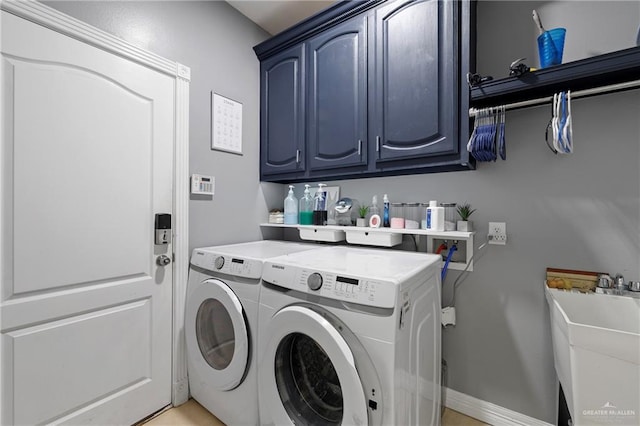 washroom with sink, cabinets, and washing machine and clothes dryer