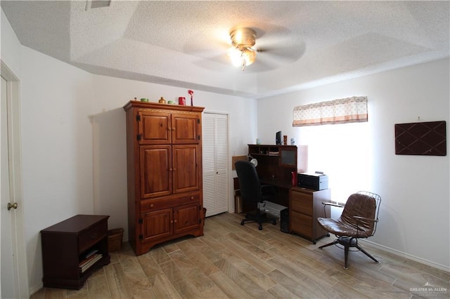 office space with ceiling fan, a textured ceiling, and light wood-type flooring