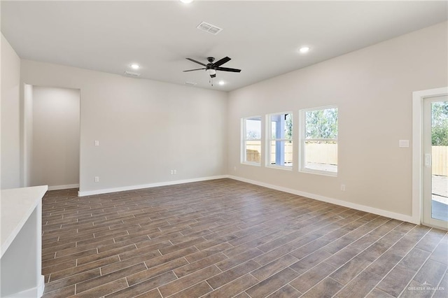 unfurnished living room featuring dark wood-type flooring and ceiling fan