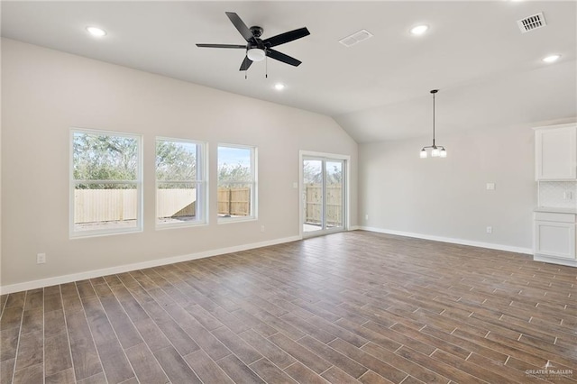 unfurnished living room with dark wood-type flooring, vaulted ceiling, and ceiling fan with notable chandelier