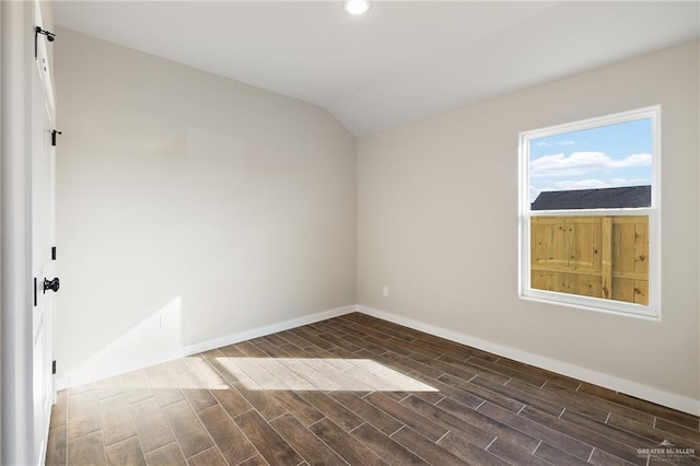 unfurnished room with vaulted ceiling